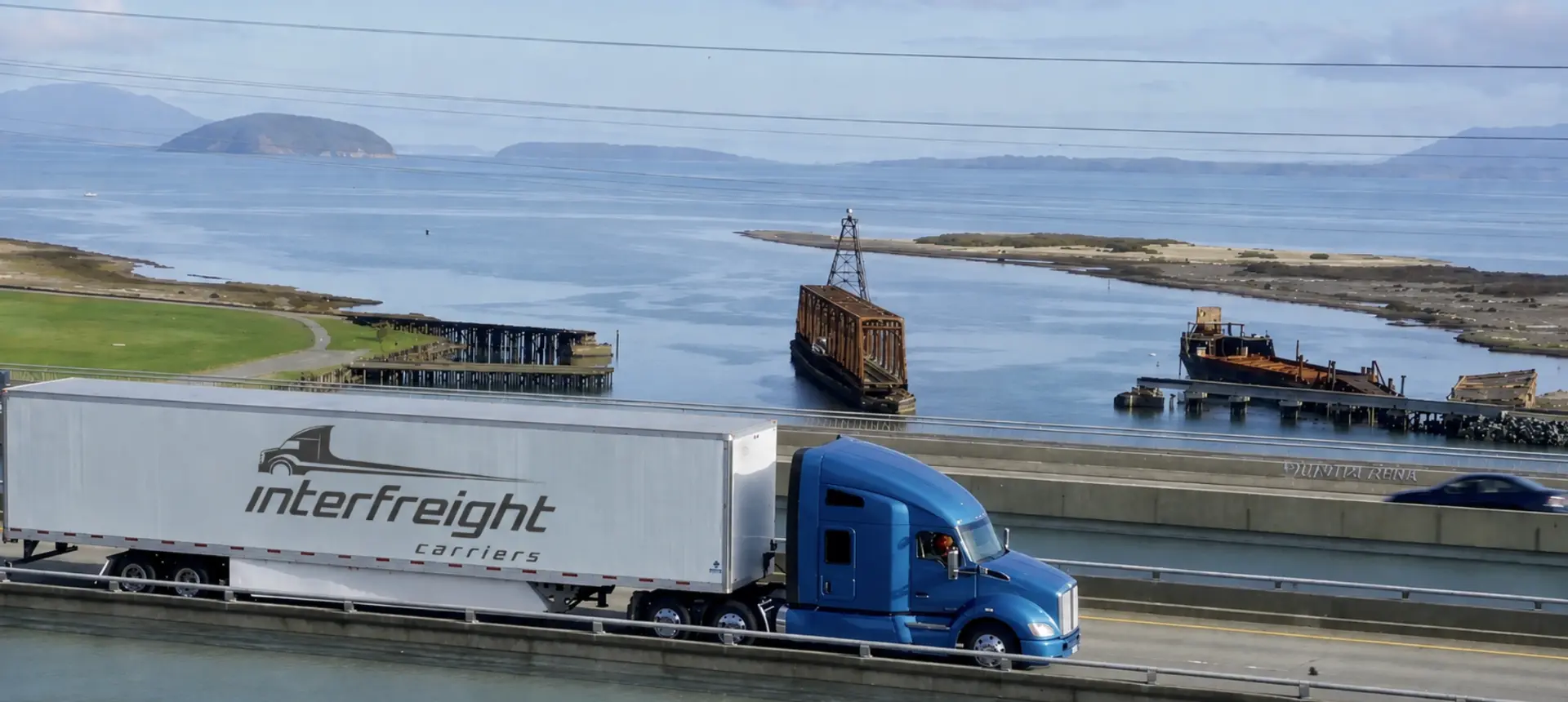 Interfreight Carriers truck on a coastal highway bridge